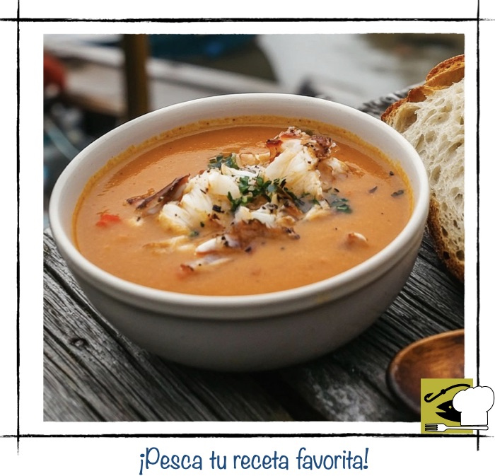 Plato de bisque de cangrejo cremoso con trozos de carne de marisco fresca y perejil.
