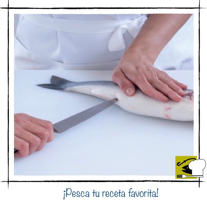 Una persona a punto de eviscerar un pescado, con un corte que va desde el orificio anal hacia la cabeza.