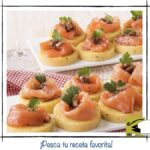 Crostini de polenta redondos con láminas de salmón ahumado y hierbas frescas.