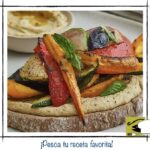 Tosta vegetariana de hummus con verduras asadas como pimiento calabacín y albahaca.