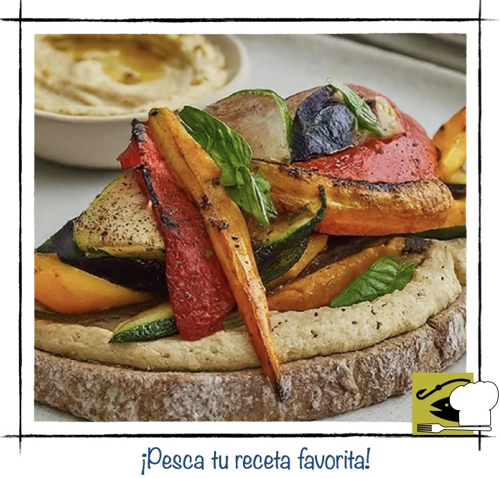 Tosta vegetariana de hummus con verduras asadas como pimiento calabacín y albahaca.